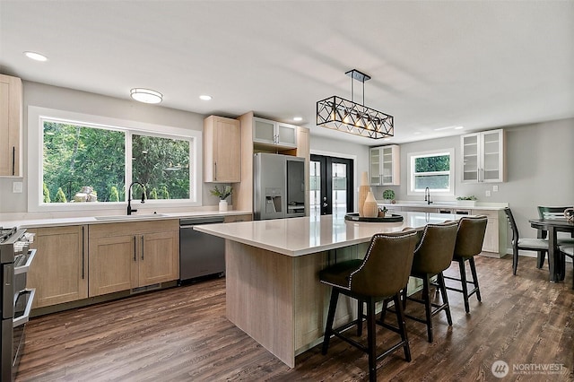 22526 251st Ave SE, Maple Valley, WA 98038 - kitchen with stainless steel appliances, glass insert cabinets, a breakfast bar area, a kitchen island, and recessed lighting