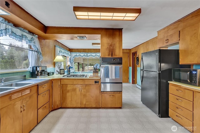 40515 228th Way SE, Enumclaw, WA 98022 - kitchen featuring black appliances, a warming drawer, light countertops, light floors, and brown cabinets