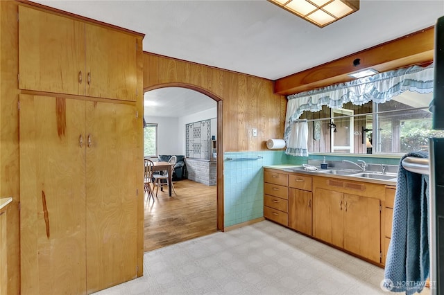 40515 228th Way SE, Enumclaw, WA 98022 - kitchen with arched walkways, wooden walls, light flooring, light countertops, and brown cabinets