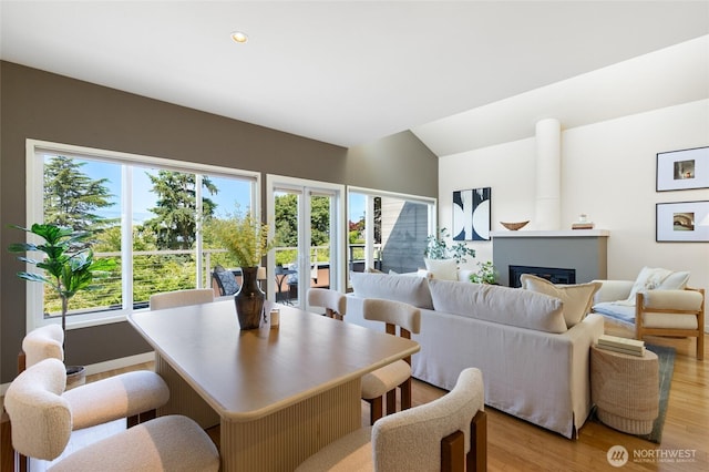 101 NW 58th St Unit 10, Seattle, WA 98107 - dining room with light wood-style flooring, vaulted ceiling, a glass covered fireplace, and recessed lighting