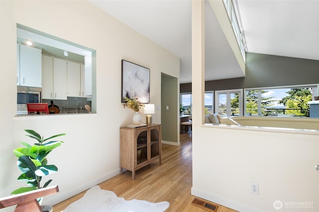 101 NW 58th St Unit 10, Seattle, WA 98107 - corridor featuring light wood-style floors and vaulted ceiling