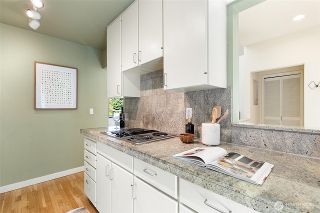 101 NW 58th St Unit 10, Seattle, WA 98107 - kitchen with stainless steel electric cooktop, light countertops, white cabinetry, and light wood-type flooring