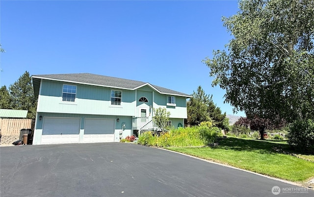 16 River Overlook St, Omak, WA 98841 - bi-level home featuring a garage, asphalt driveway, and a front yard