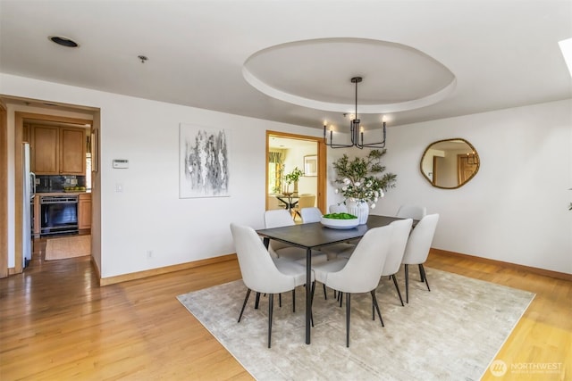 10135 NE 64th St Unit A, Kirkland, WA 98033 - dining area with a chandelier, a raised ceiling, and light wood-style floors