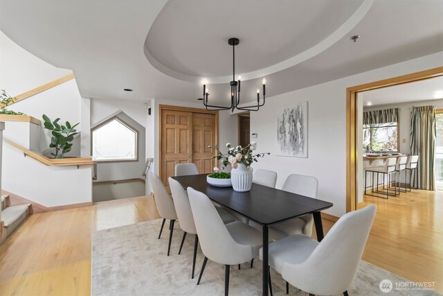 10135 NE 64th St Unit A, Kirkland, WA 98033 - dining space with a chandelier, wood finished floors, stairs, and a tray ceiling
