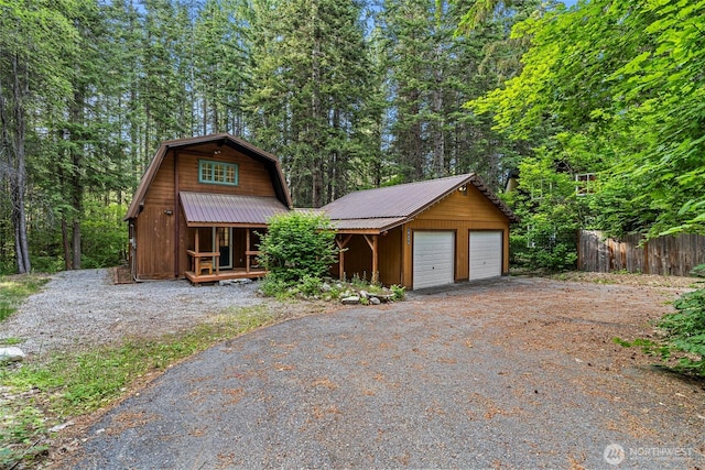 18690 Rieche Rd, Lake Wenatchee, WA 98826 - view of front of home with a garage, a metal roof, a gambrel roof, an outbuilding, and covered porch