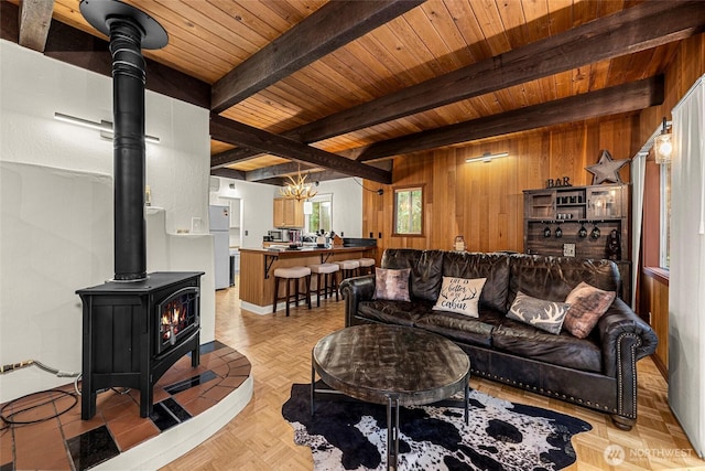 18690 Rieche Rd, Lake Wenatchee, WA 98826 - living room with a wood stove, wood walls, a wooden ceiling with exposed beams, and a chandelier