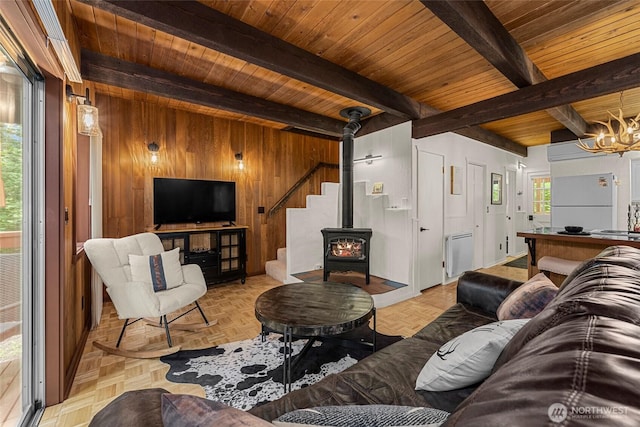 18690 Rieche Rd, Lake Wenatchee, WA 98826 - living area featuring wooden walls, a wooden ceiling with exposed beams, a chandelier, and a wood stove