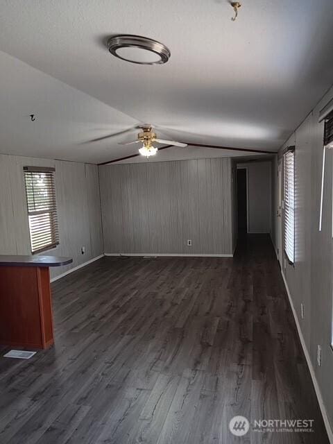 900 N Grape Dr Unit 36, Moses Lake, WA 98337 - unfurnished living room with lofted ceiling, a ceiling fan, dark wood-style flooring, and wooden walls
