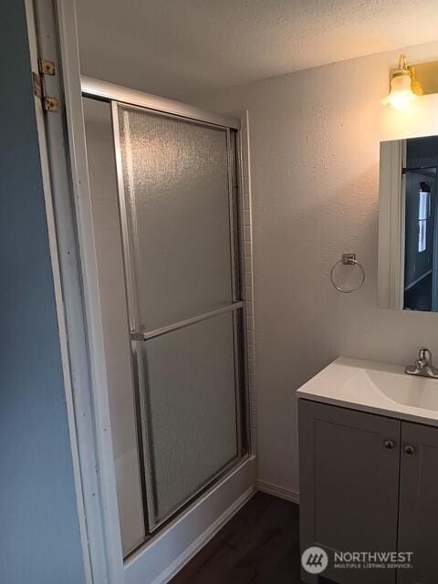 900 N Grape Dr Unit 36, Moses Lake, WA 98337 - bathroom featuring vanity, a stall shower, and wood finished floors