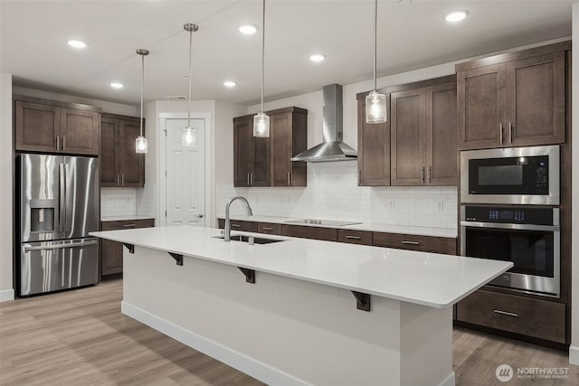 20424 E 97th Ave E Unit 6, Graham, WA 98338 - kitchen with appliances with stainless steel finishes, wall chimney exhaust hood, dark brown cabinets, a breakfast bar, and recessed lighting
