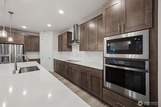 20424 E 97th Ave E Unit 6, Graham, WA 98338 - kitchen with stainless steel appliances, wall chimney exhaust hood, light countertops, dark brown cabinetry, and backsplash