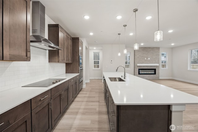 20424 E 97th Ave E Unit 6, Graham, WA 98338 - kitchen featuring wall chimney exhaust hood, black electric cooktop, light wood finished floors, backsplash, and recessed lighting