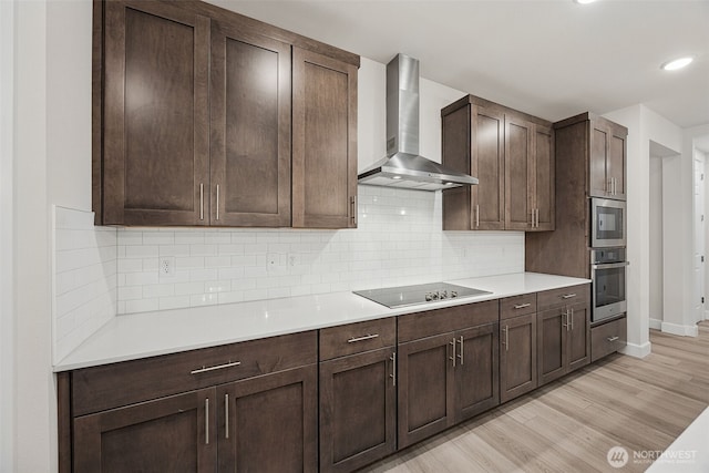 20424 E 97th Ave E Unit 6, Graham, WA 98338 - kitchen with wall chimney range hood, black electric stovetop, oven, light wood finished floors, and light countertops