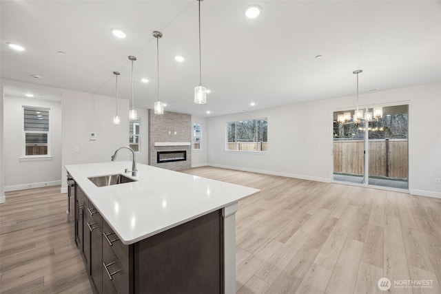 20424 E 97th Ave E Unit 6, Graham, WA 98338 - kitchen with a large fireplace, light wood-type flooring, a chandelier, light countertops, and recessed lighting