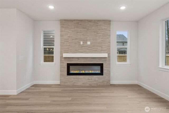 20424 E 97th Ave E Unit 6, Graham, WA 98338 - unfurnished living room with wood finished floors, a tiled fireplace, and recessed lighting
