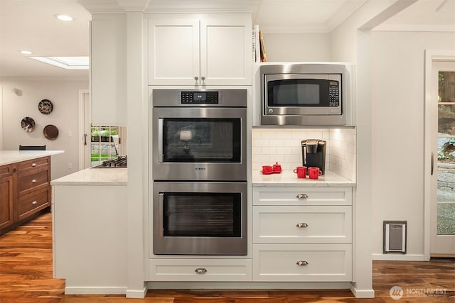 12810 NE 32nd Pl, Bellevue, WA 98005 - kitchen with appliances with stainless steel finishes, plenty of natural light, crown molding, decorative backsplash, and wood finished floors