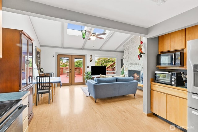 50 Hemlock Way, Sequim, WA 98382 - living room featuring light wood-style flooring, french doors, a skylight, a fireplace, and a ceiling fan