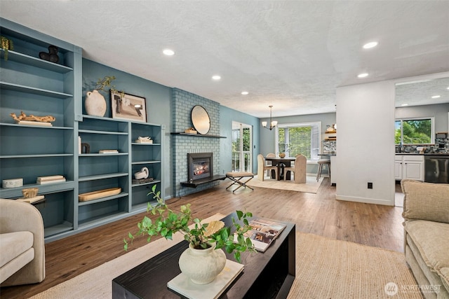 933 N Stephenson, Montesano, WA 98563 - living area featuring recessed lighting, wood finished floors, a brick fireplace, a textured ceiling, and a chandelier