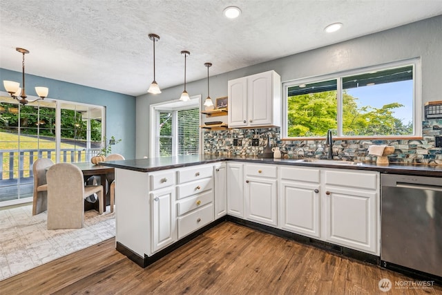 933 N Stephenson, Montesano, WA 98563 - kitchen with stainless steel dishwasher, dark countertops, a peninsula, backsplash, and a textured ceiling
