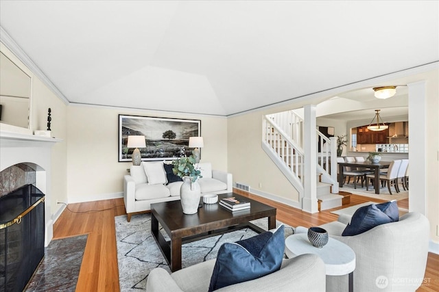 2906W Eaton St, Seattle, WA 98199 - living area with a fireplace, wood finished floors, arched walkways, stairs, and lofted ceiling