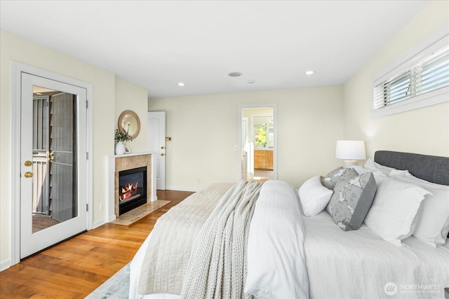 2906W Eaton St, Seattle, WA 98199 - bedroom featuring multiple windows, wood finished floors, a tiled fireplace, recessed lighting, and connected bathroom