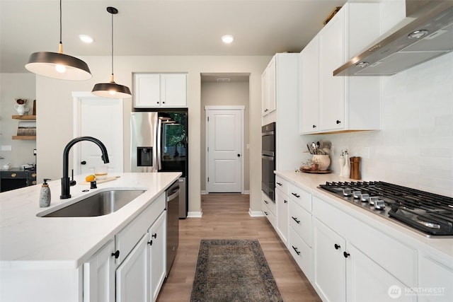 2405 NE Waterlily Way, Poulsbo, WA 98370 - kitchen featuring wall chimney exhaust hood, appliances with stainless steel finishes, white cabinetry, light wood-style floors, and recessed lighting
