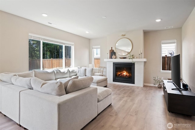 2405 NE Waterlily Way, Poulsbo, WA 98370 - living room with light wood finished floors, a glass covered fireplace, and recessed lighting