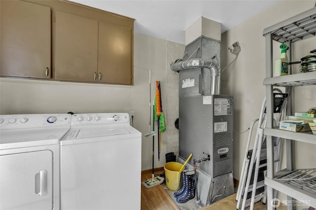 4723 50th Ave SW, Seattle, WA 98116 - laundry room with cabinet space, separate washer and dryer, light wood-type flooring, and heating unit