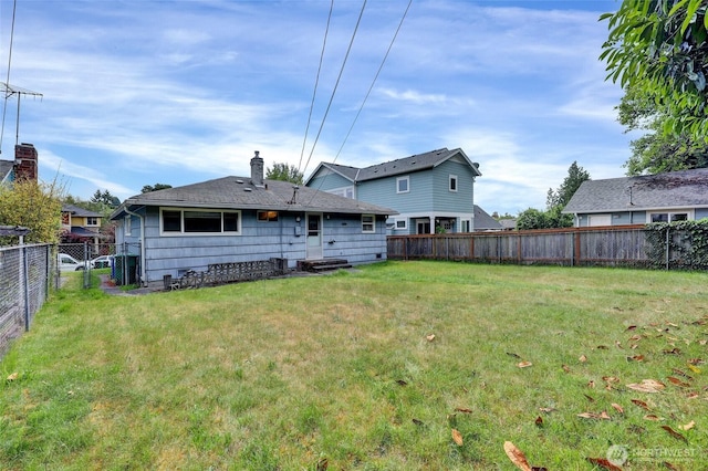 4723 50th Ave SW, Seattle, WA 98116 - rear view of house featuring a fenced backyard and a chimney