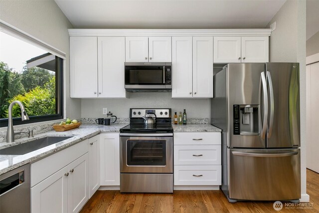 11520 3rd Ave NW, Seattle, WA 98177 - kitchen with appliances with stainless steel finishes, white cabinets, and light stone countertops
