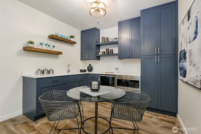 11520 3rd Ave NW, Seattle, WA 98177 - kitchen featuring open shelves, stainless steel microwave, light wood finished floors, beverage cooler, and light countertops