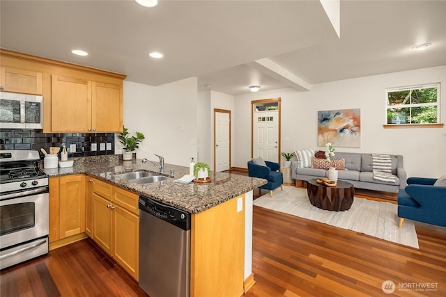 10290 NE Ruddy Duck Ln, Bainbridge Island, WA 98110 - kitchen featuring appliances with stainless steel finishes, open floor plan, dark wood-type flooring, a peninsula, and dark stone countertops