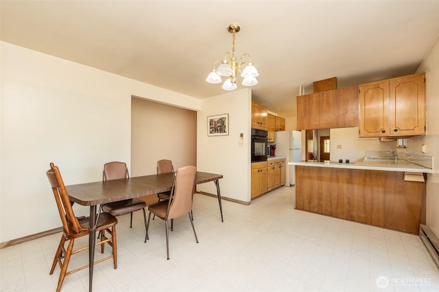 723 W 15th St, Port Angeles, WA 98363 - dining room featuring a chandelier, light floors, and a baseboard heating unit