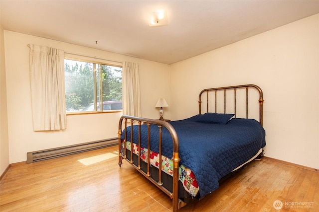 723 W 15th St, Port Angeles, WA 98363 - bedroom with baseboard heating and wood finished floors