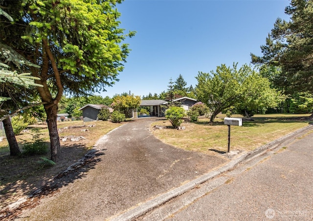 723 W 15th St, Port Angeles, WA 98363 - view of property hidden behind natural elements featuring asphalt driveway and a front yard