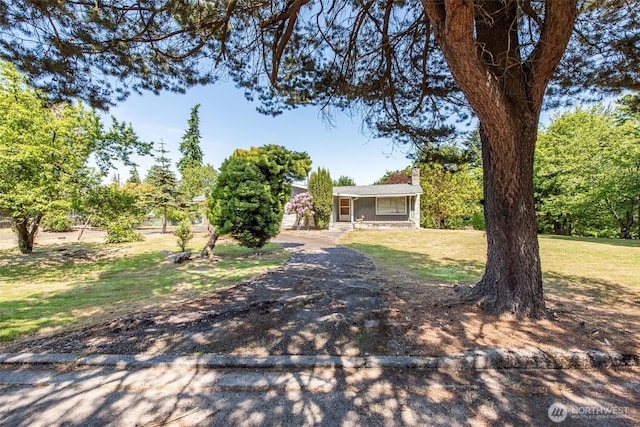 723 W 15th St, Port Angeles, WA 98363 - view of front of property with a chimney, a front yard, and dirt driveway