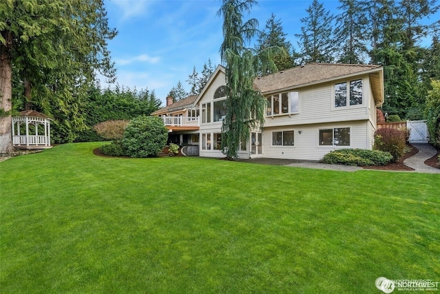 9416 NE 25th St, Clyde Hill, WA 98004 - rear view of house with a lawn, a chimney, and a deck