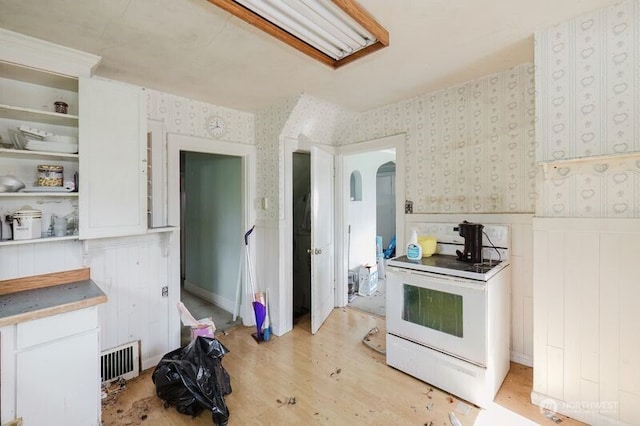 7936 E Main St, Port Orchard, WA 98366 - kitchen with electric stove, wallpapered walls, wainscoting, arched walkways, and light wood-type flooring