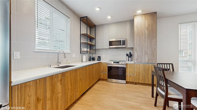1300 E Remington Ct Unit A, Seattle, WA 98122 - kitchen featuring stainless steel appliances, modern cabinets, backsplash, light wood-type flooring, and recessed lighting