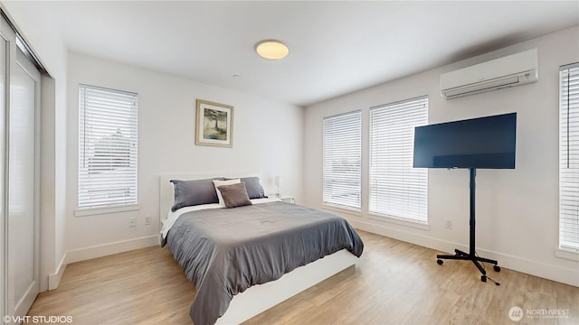 1300 E Remington Ct Unit A, Seattle, WA 98122 - bedroom featuring a wall mounted AC, light wood-style floors, and multiple windows