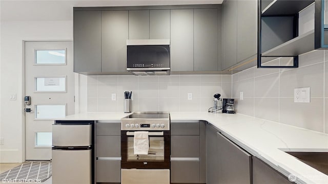1300 E Remington Ct Unit A, Seattle, WA 98122 - kitchen featuring gray cabinetry, appliances with stainless steel finishes, tasteful backsplash, light stone countertops, and modern cabinets
