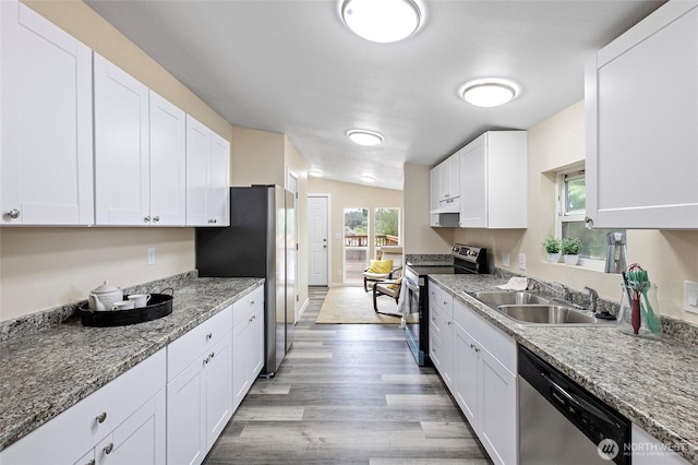 1320 N Oak Harbor St Unit 1, Oak Harbor, WA 98277 - kitchen with appliances with stainless steel finishes, white cabinets, light wood-type flooring, under cabinet range hood, and light stone counters