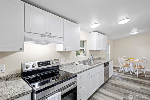 1320 N Oak Harbor St Unit 1, Oak Harbor, WA 98277 - kitchen with appliances with stainless steel finishes, under cabinet range hood, white cabinets, and light wood-style floors