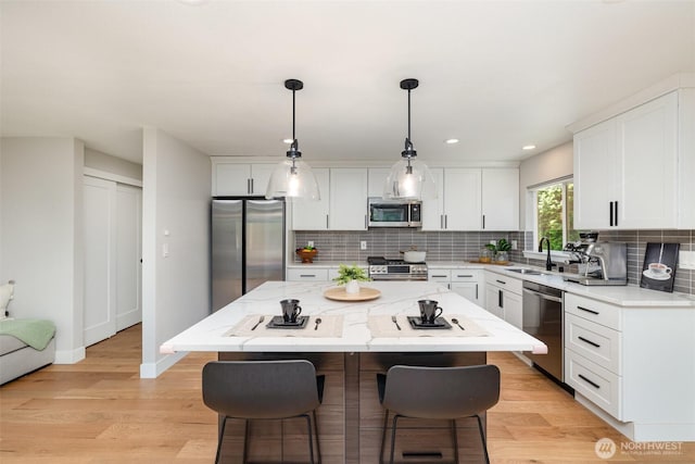 18114 NE 23rd St, Redmond, WA 98052 - kitchen with appliances with stainless steel finishes, a kitchen breakfast bar, backsplash, and recessed lighting