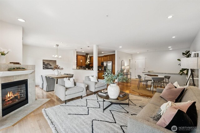 2551 Thorndyke Ave W Unit 203, Seattle, WA 98199 - living room with recessed lighting, a tiled fireplace, light wood-style floors, and a chandelier