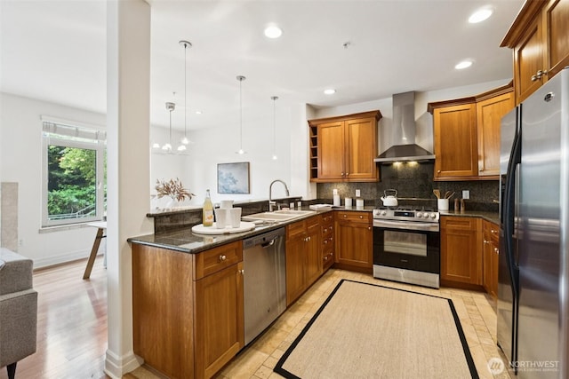 2551 Thorndyke Ave W Unit 203, Seattle, WA 98199 - kitchen featuring wall chimney range hood, stainless steel appliances, brown cabinetry, a peninsula, and recessed lighting