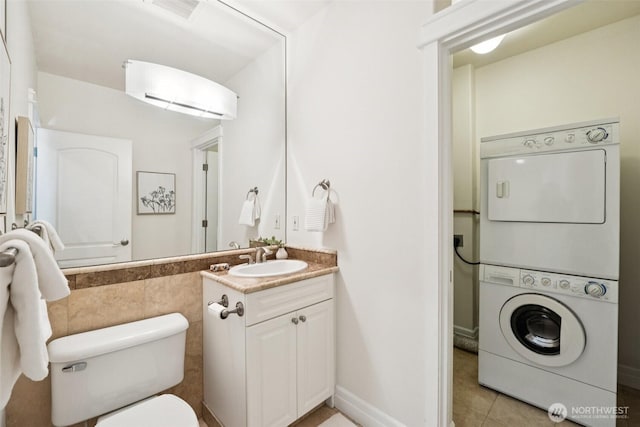 2551 Thorndyke Ave W Unit 203, Seattle, WA 98199 - half bathroom featuring stacked washing machine and dryer, vanity, and tile patterned floors