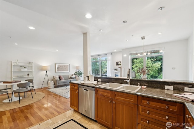 2551 Thorndyke Ave W Unit 203, Seattle, WA 98199 - kitchen with stainless steel dishwasher, brown cabinets, hanging light fixtures, recessed lighting, and open floor plan