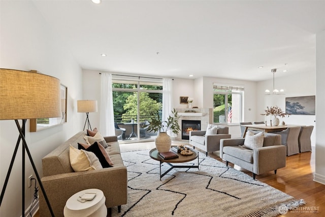 2551 Thorndyke Ave W Unit 203, Seattle, WA 98199 - living area featuring wood finished floors, a tiled fireplace, recessed lighting, and a chandelier